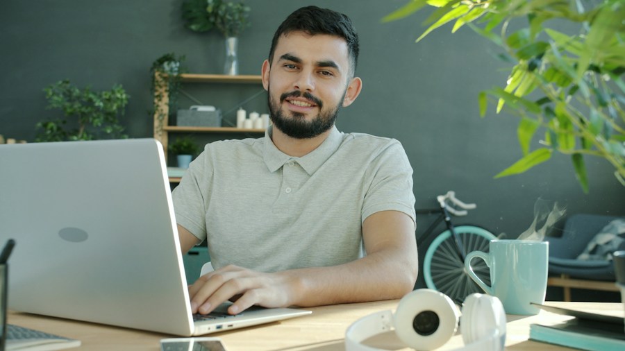 Vendedor sonriente trabajando en su portátil