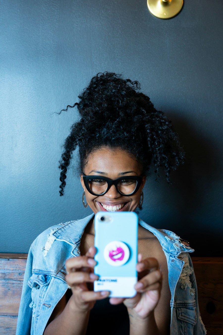 Vendedora sonriendo con su celular en la mano